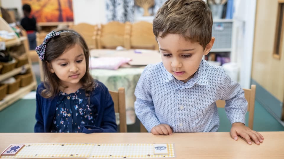 2 children looking at maths game